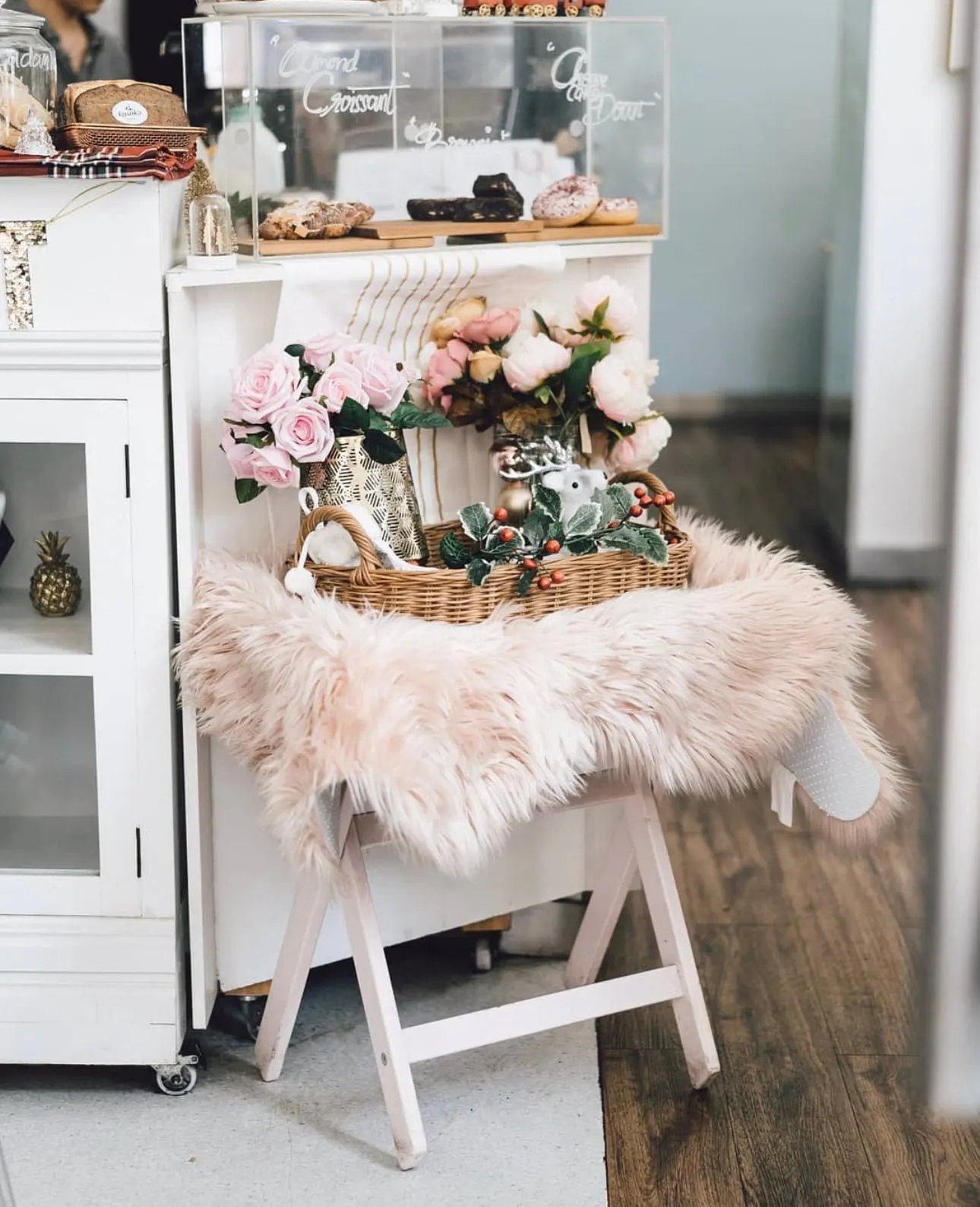 Dessert cart styled with pastel florals, cakes and a sheepskin throw