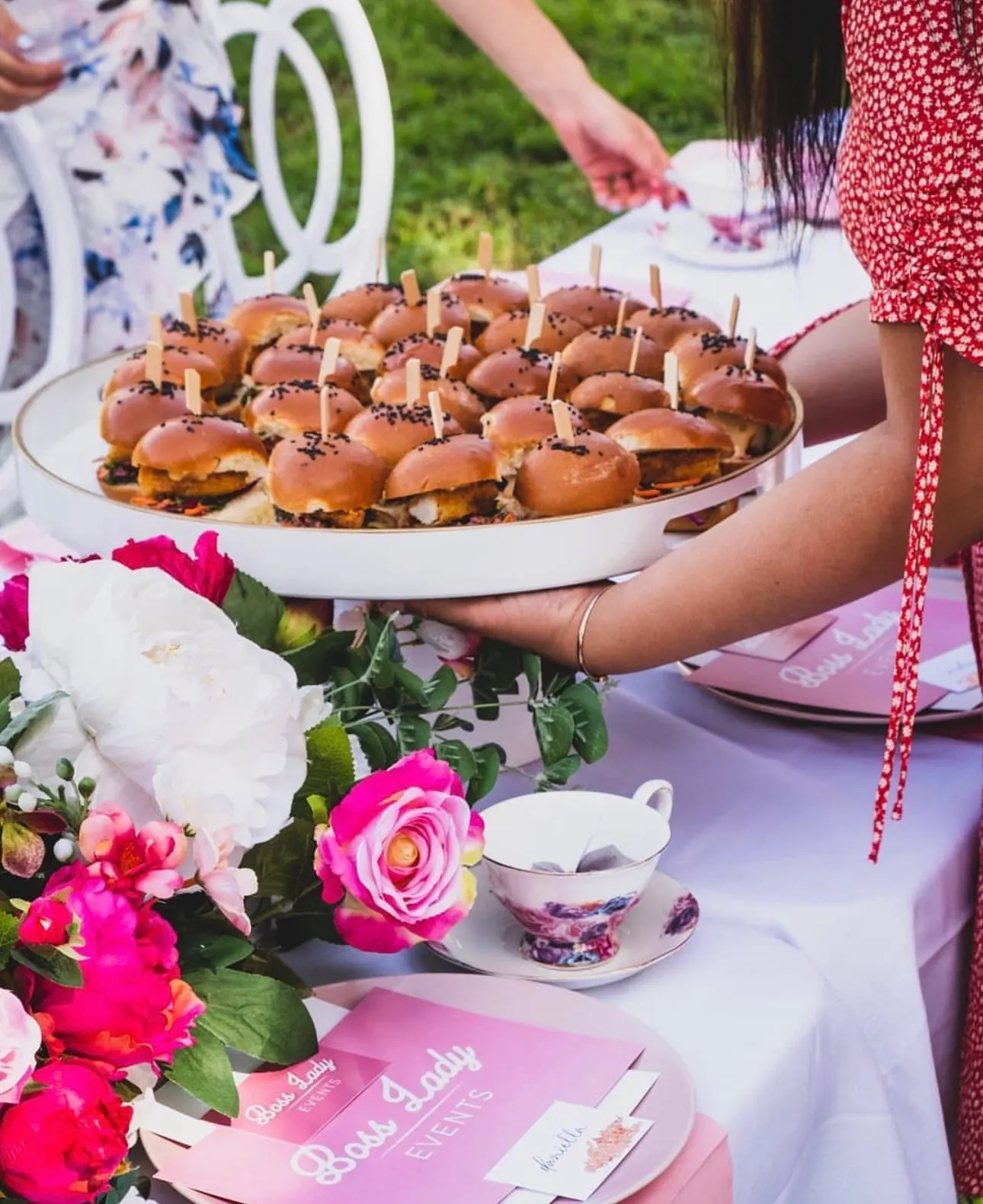 High tea spread with sliders, florals and floral-print teacups