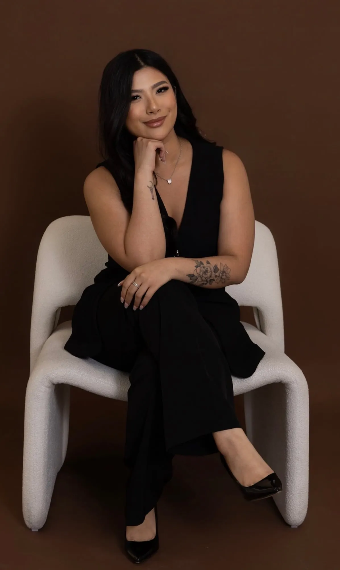 Portrait of a member of the Last August Events team, seated in a white chair