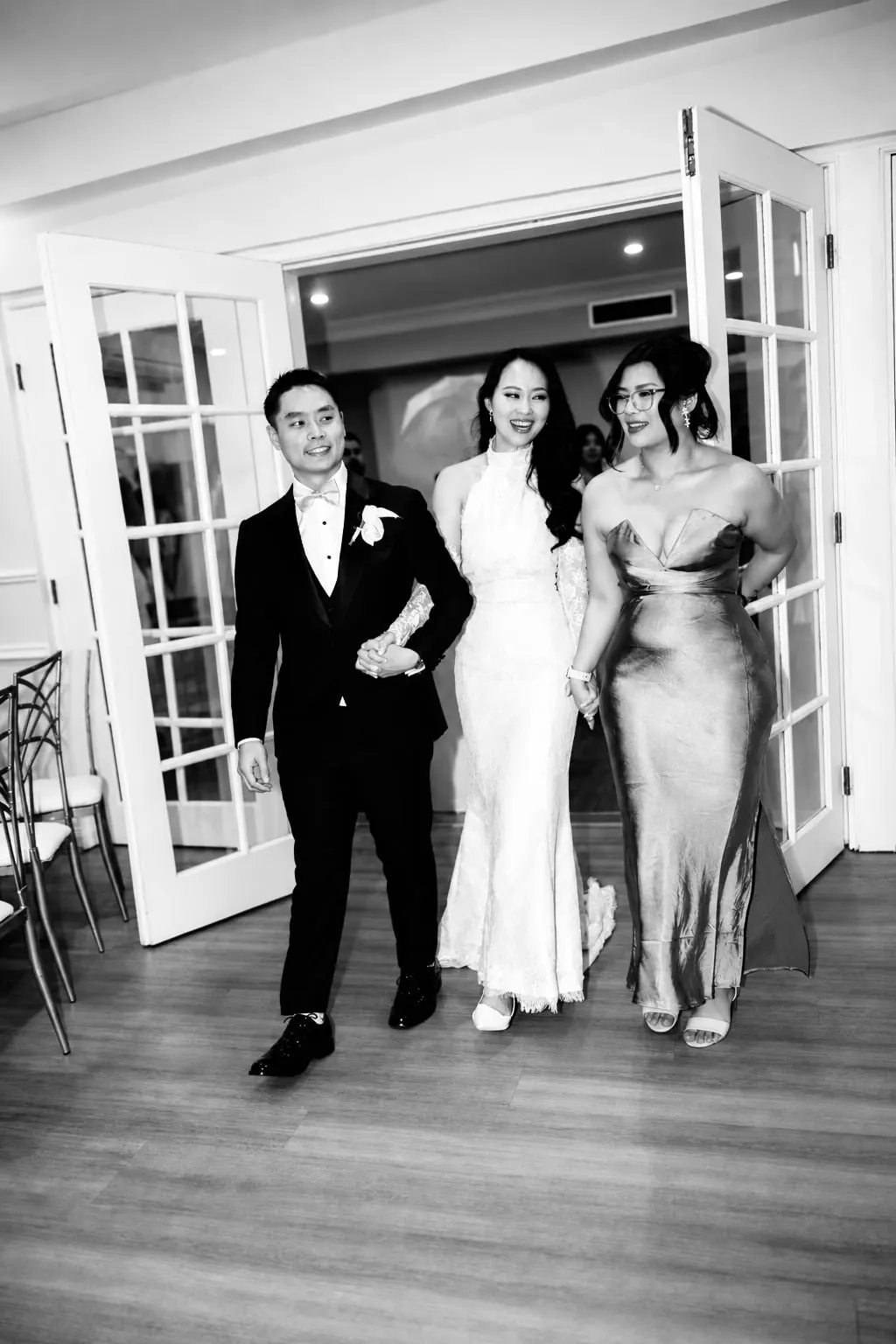 Black-and-white photo of the bridal party entering the reception