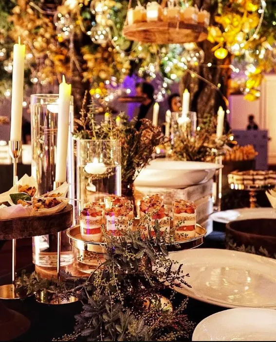 Dessert table with candles, florals and treats at an evening event