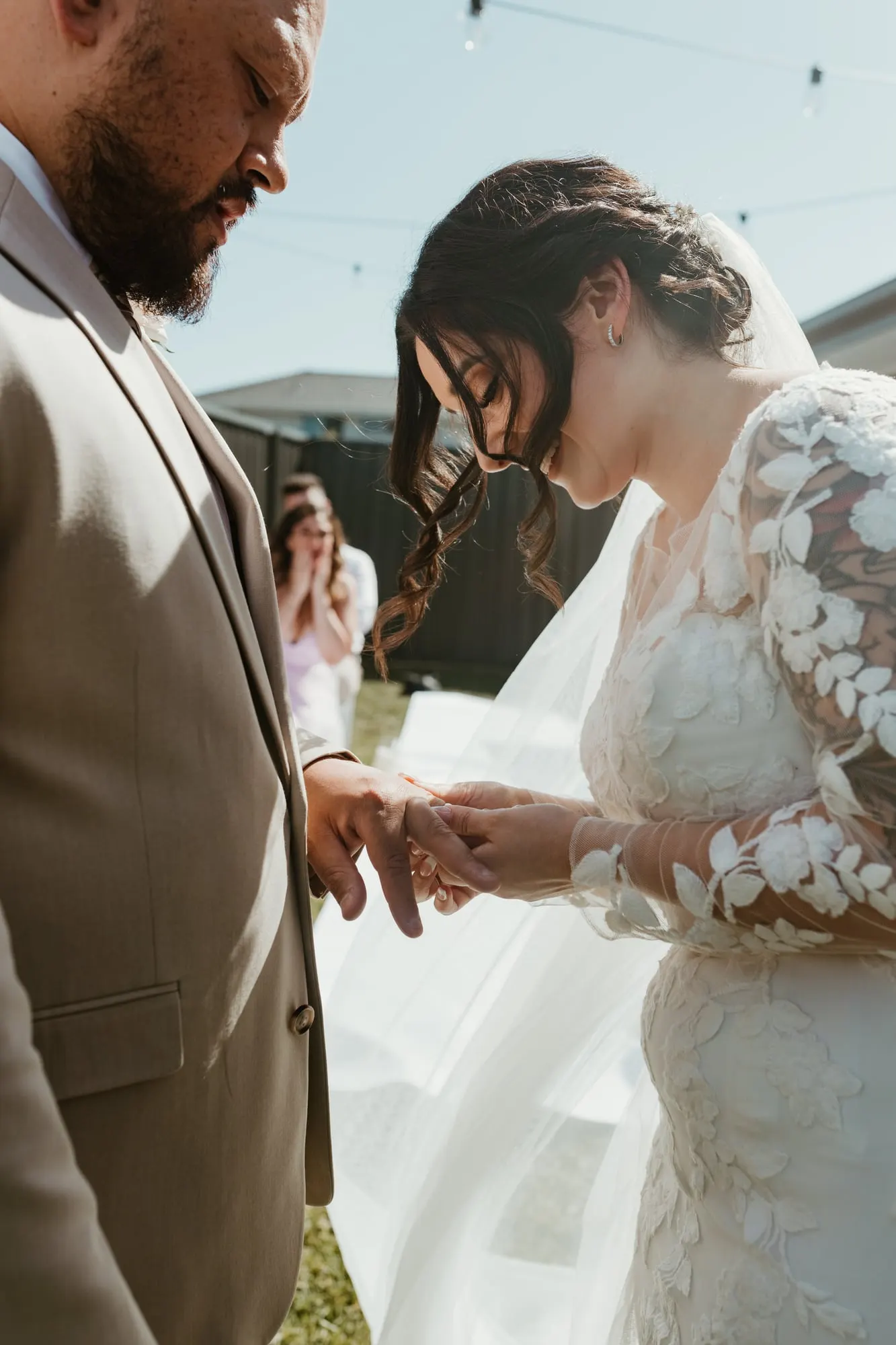 Bride placing the ring on the groom's finger during their ceremony