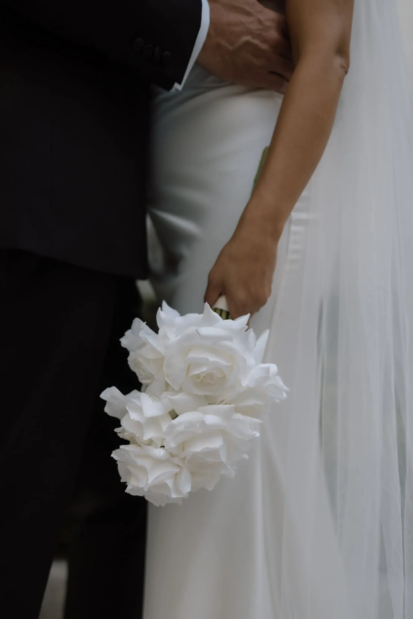 Bride holding a bouquet of classic white roses