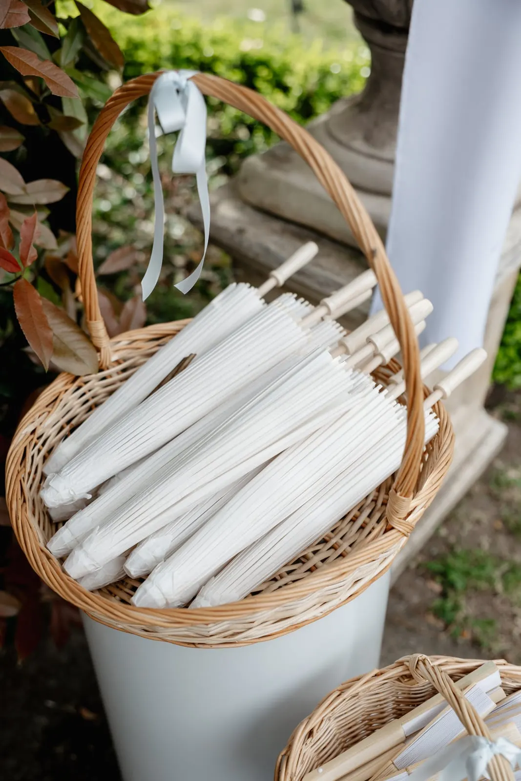 Basket of white parasols for guests