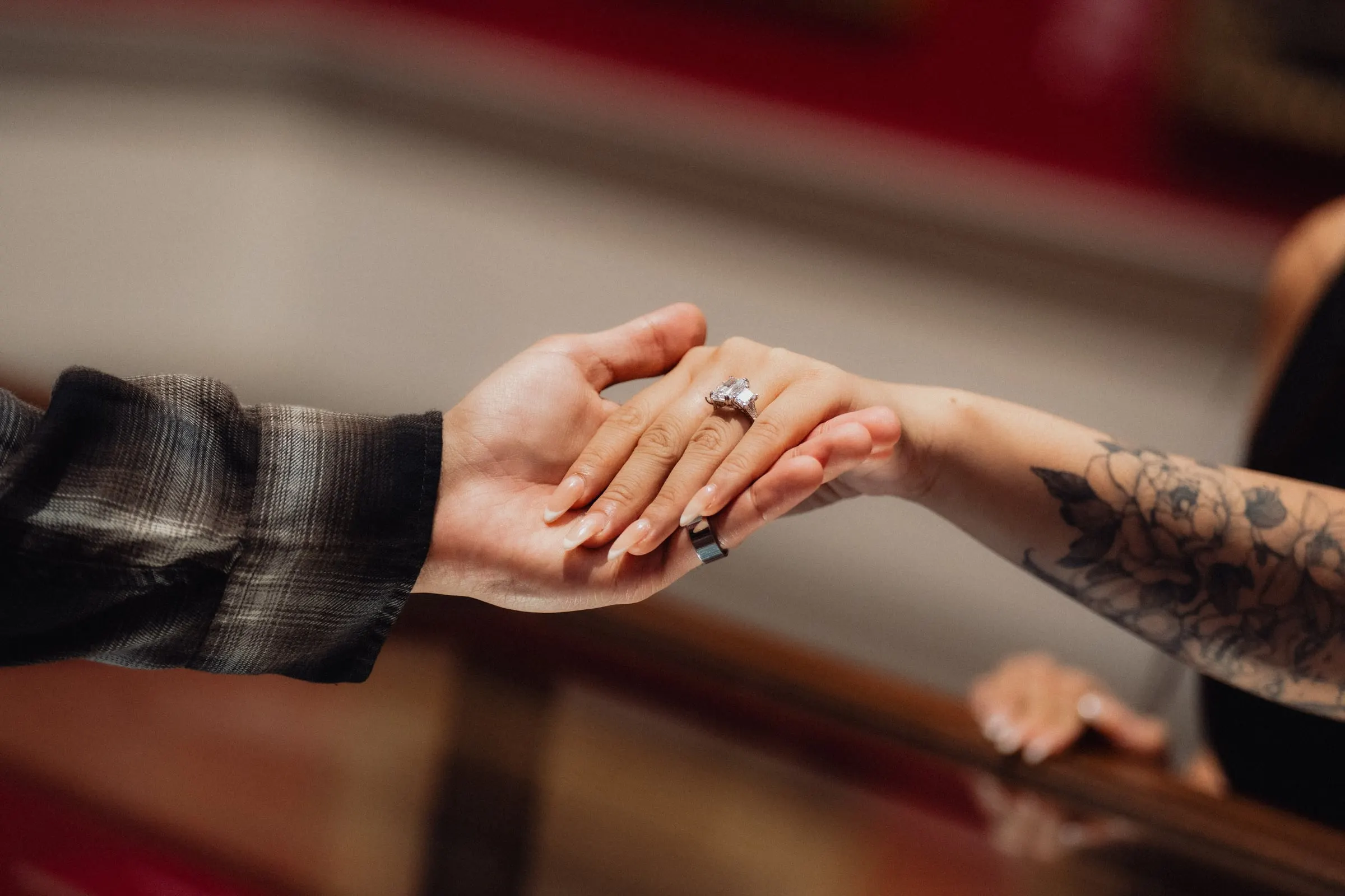 Close-up of joined hands showing a new engagement ring