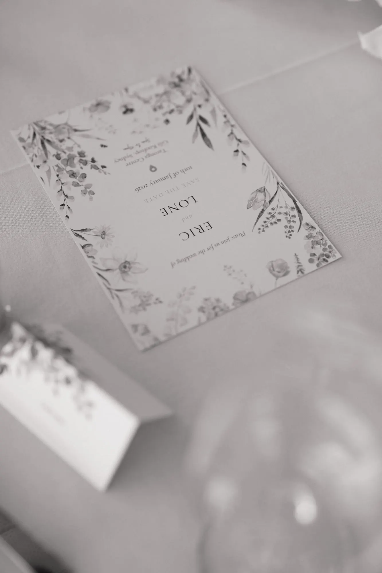 Black-and-white photo of a botanical menu card on a reception table