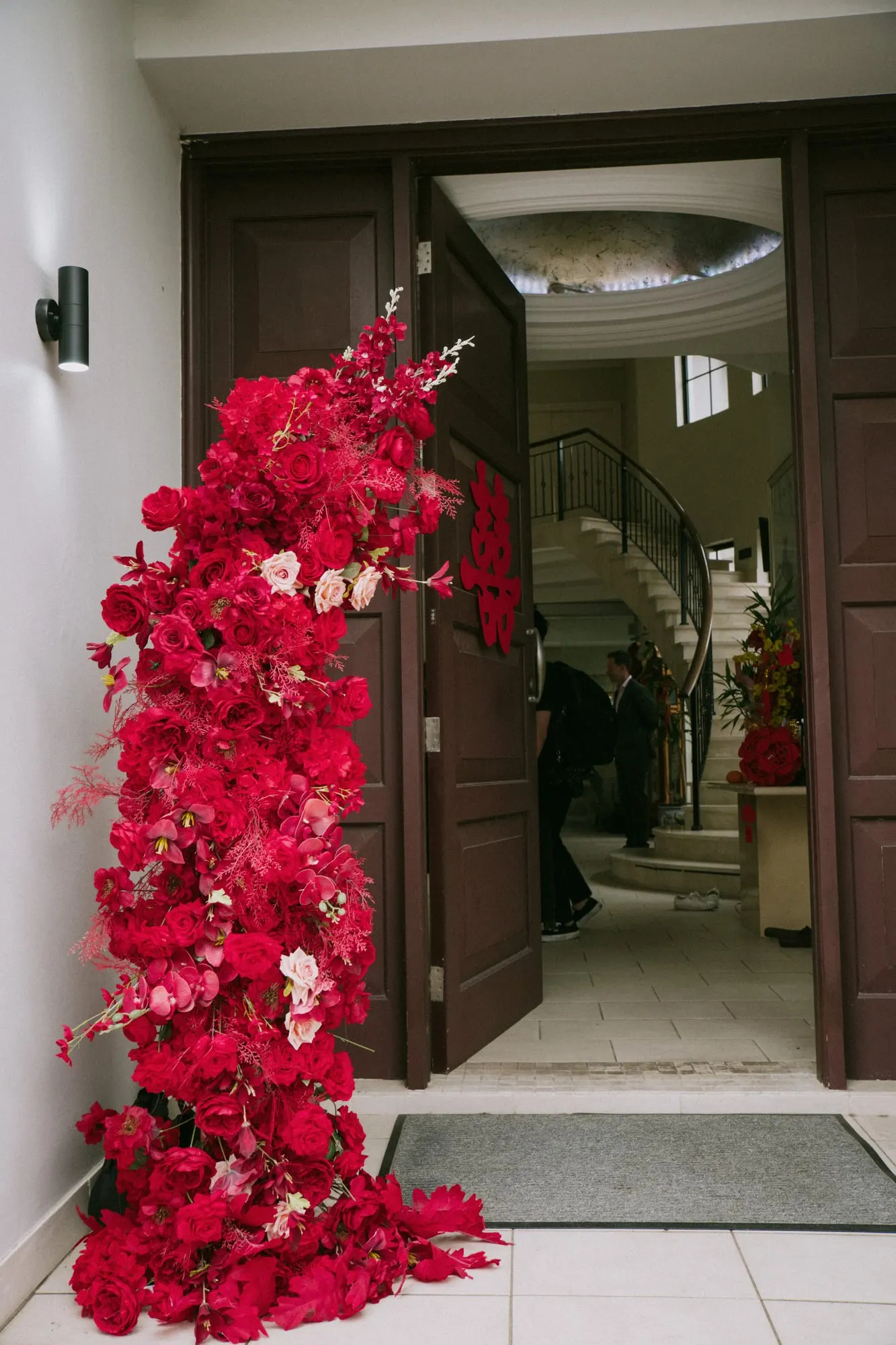 Red rose installation climbing beside an open front door