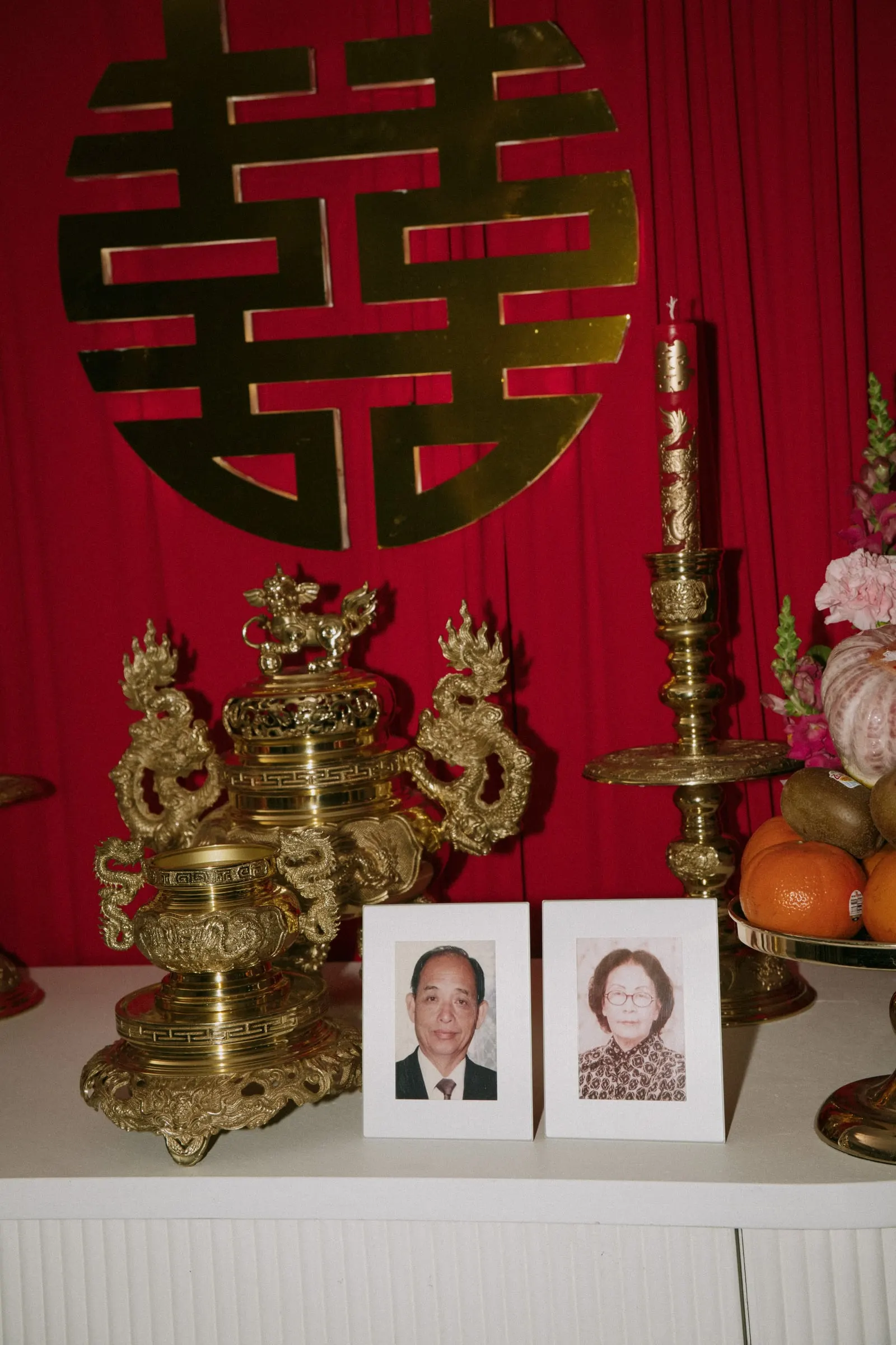 Gold double happiness symbol on a red drape above the family altar