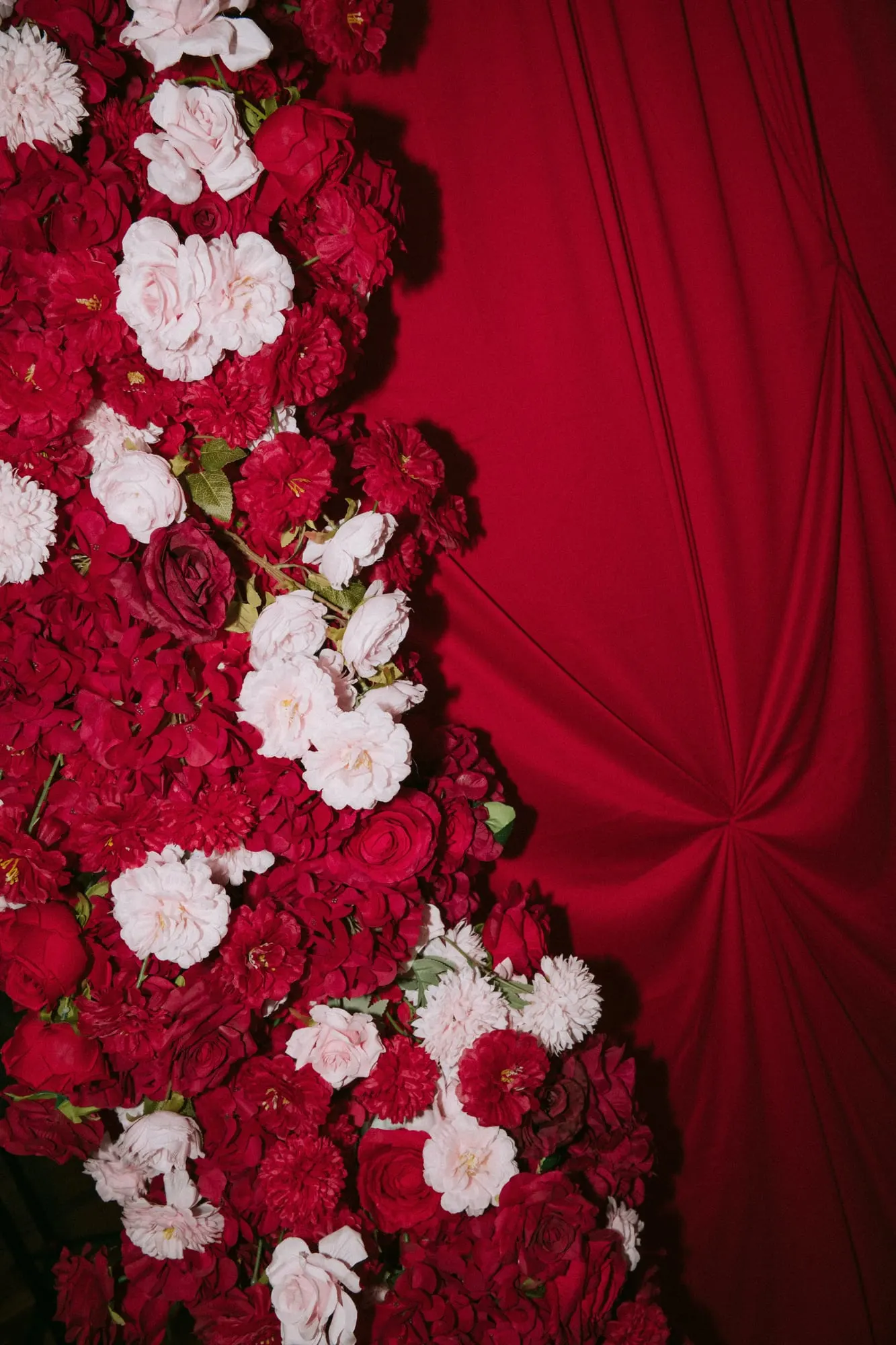 Red draped wall with red and white rose florals