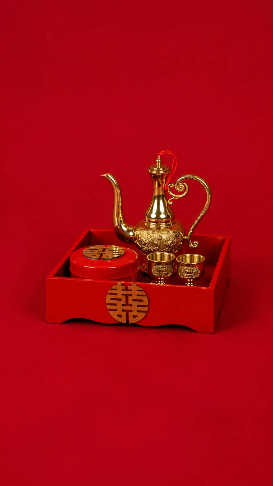 Gold teapot and cups on a red tray marked with double happiness