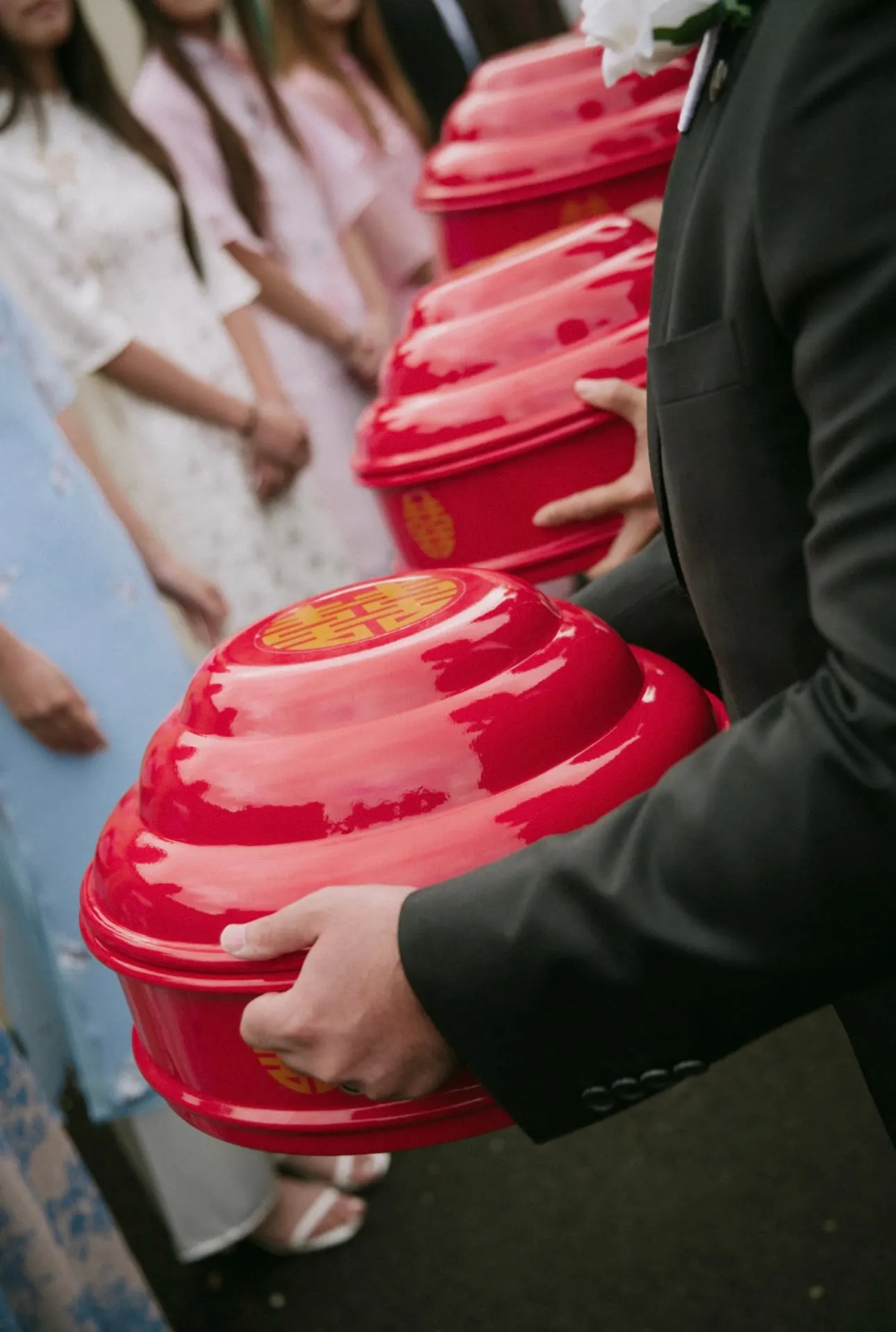Groomsmen carrying red Mam Qua gift boxes in the tea ceremony procession