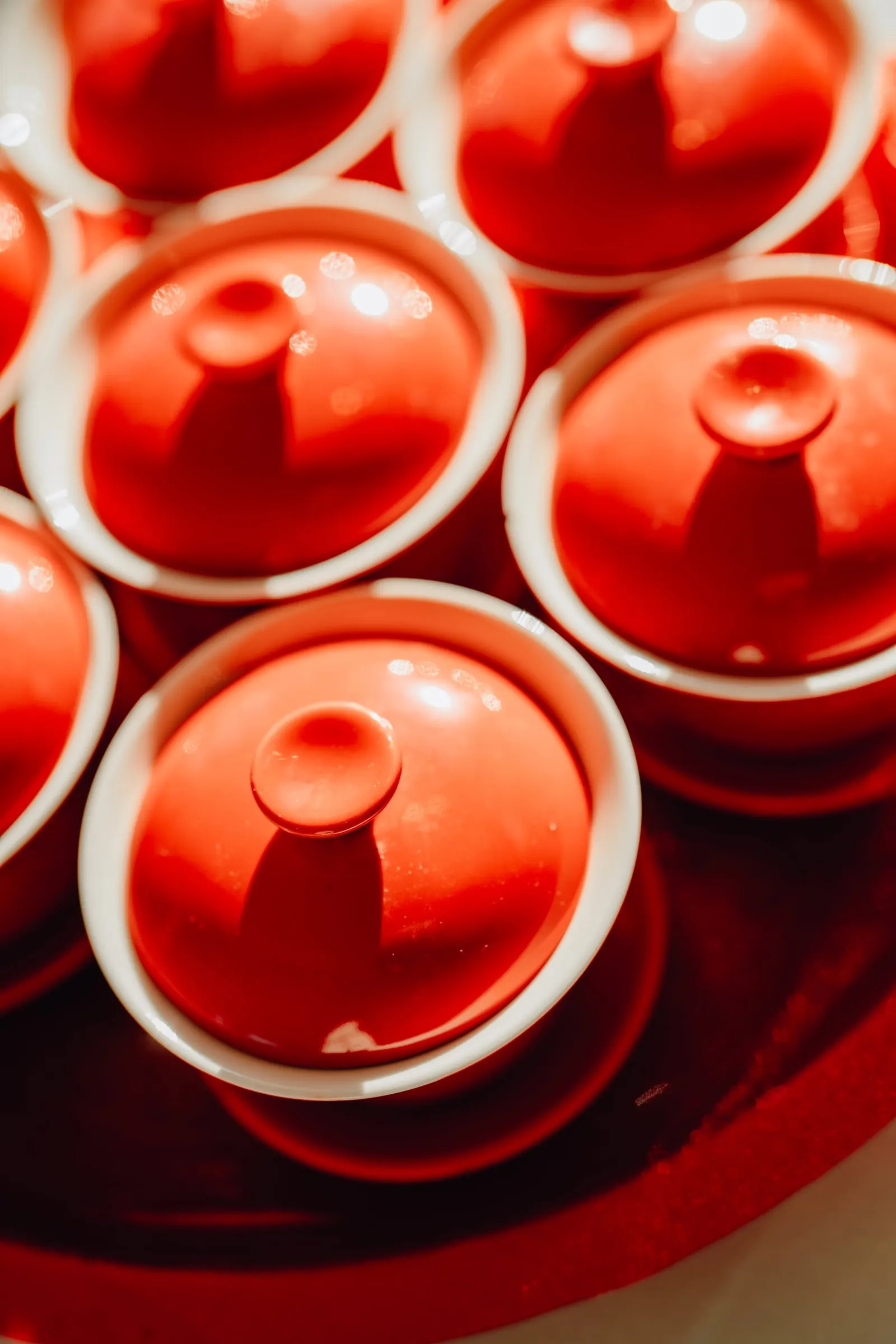 Red tea cups and lids arranged on a red tray for the tea ceremony